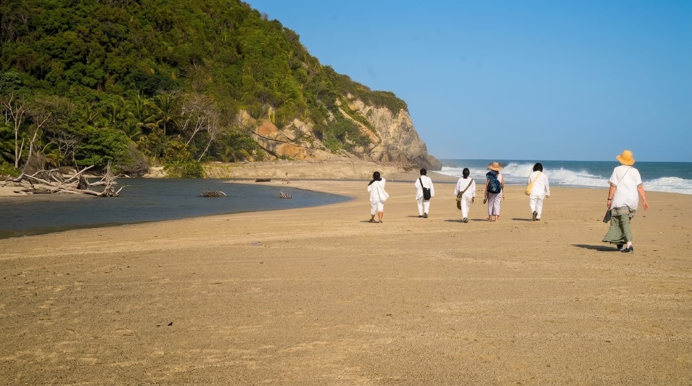 Grupo de locales vestidos de blanco caminando por una playa colombiana